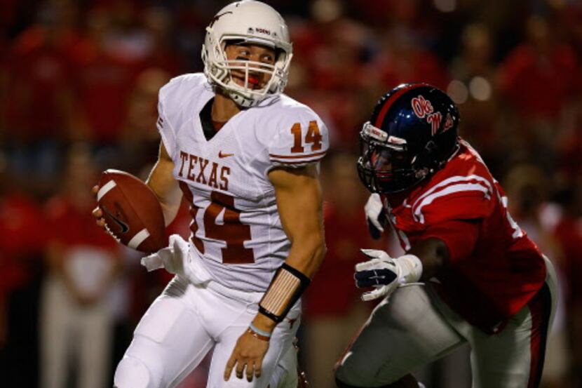 OXFORD, MS - SEPTEMBER 15: David Ash #14 of the Texas Longhorns fights off the tackle of...