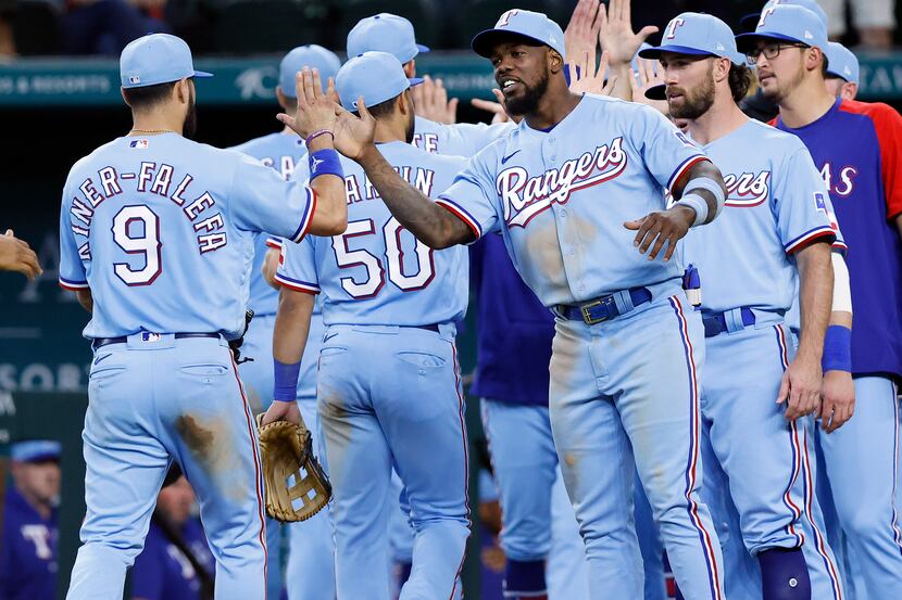 Texas Rangers right fielder Adolis Garcia (right) congratulates third baseman Isiah...