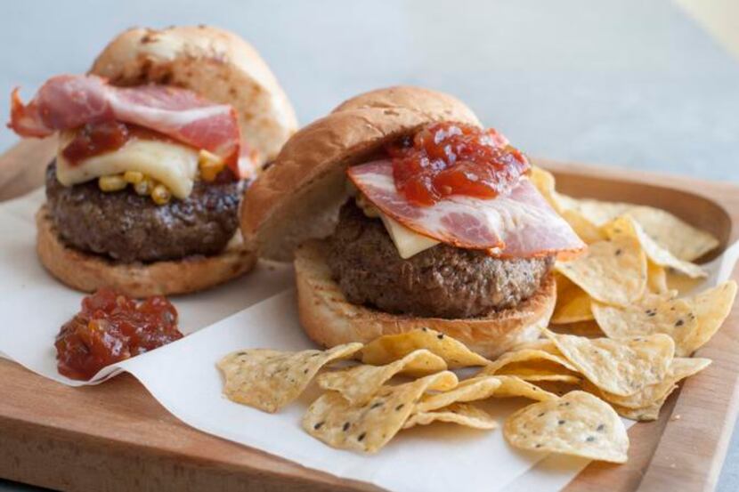 
A burger stuffed and topped with cheese pops when it’s topped with salami and relish. 
