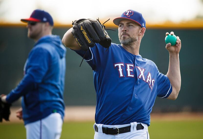 Texas Rangers pitcher Mike Minor tosses a heavy ball during a spring training workout at the...