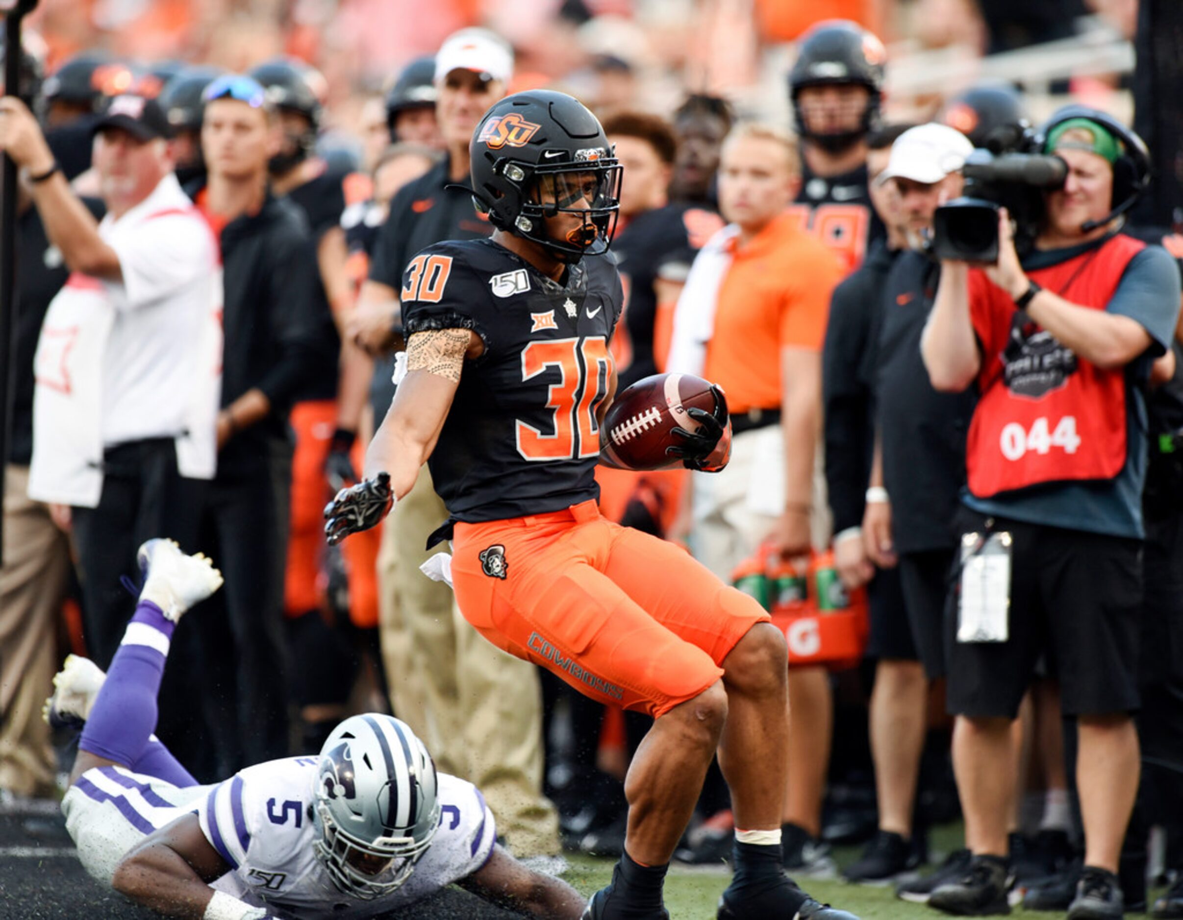 Oklahoma State wide receiver Gabe Simpson (30) escapes from Kansas State linebacker Da'Quan...