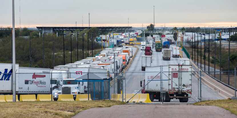 Trucks pass through the World Trade Bridge from Mexico to the U.S., left, and from the U.S....