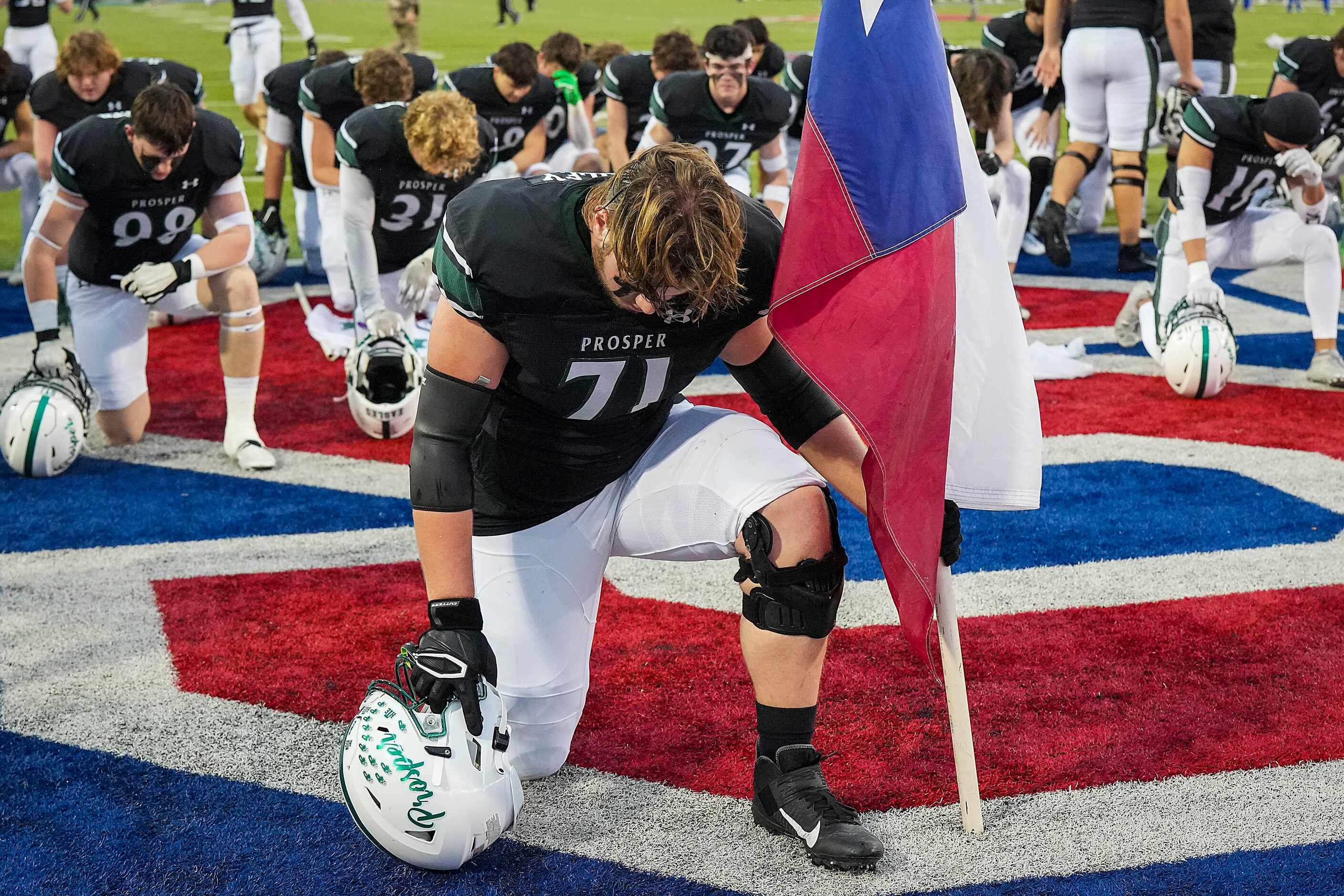 Prosper offensive lineman Colin Beesley kneels with the Texas flag before a Class 6A...