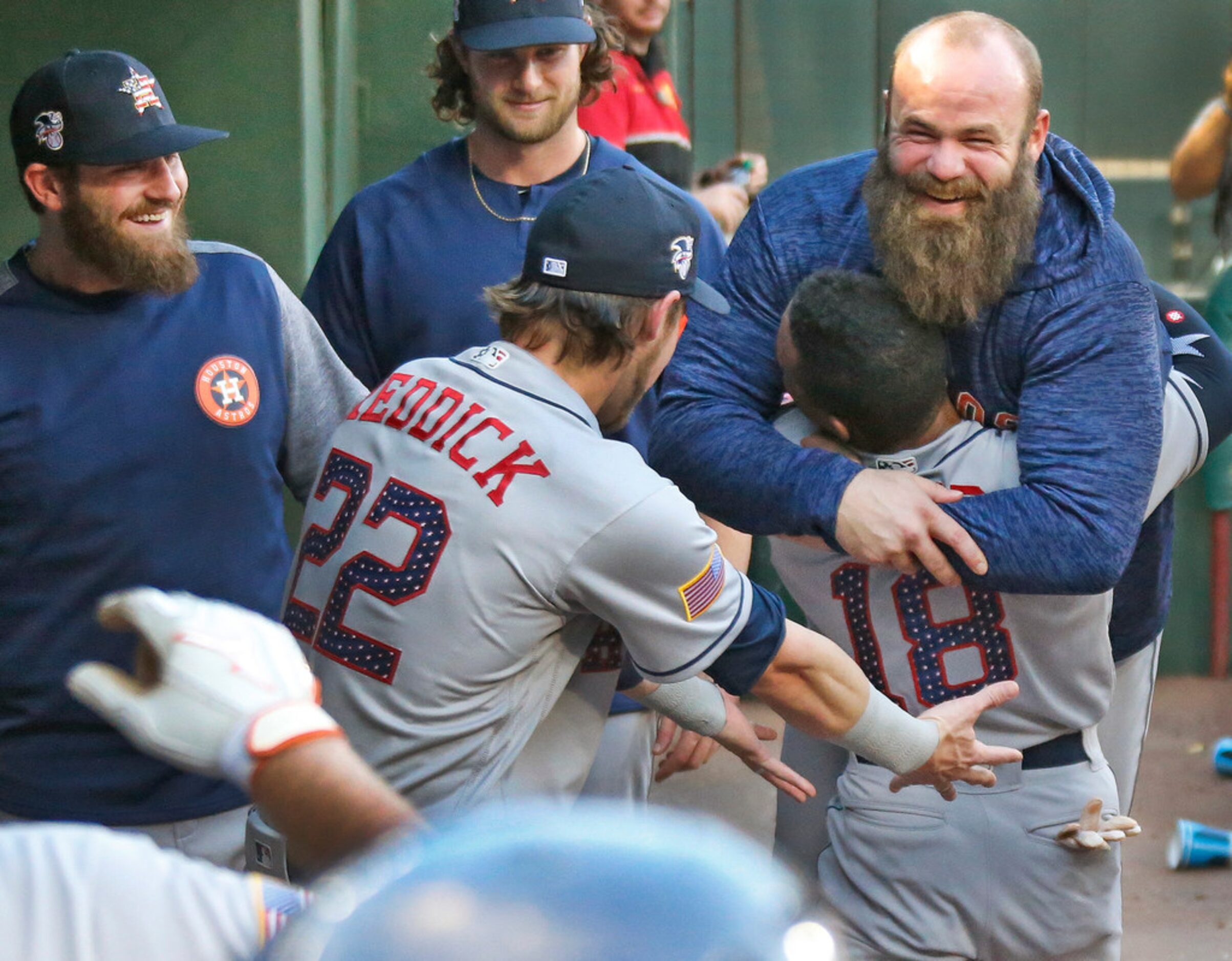 Houston Astros Tony Kemp (18) carries laughing teammate Evan Gattis (11) along the dugout...