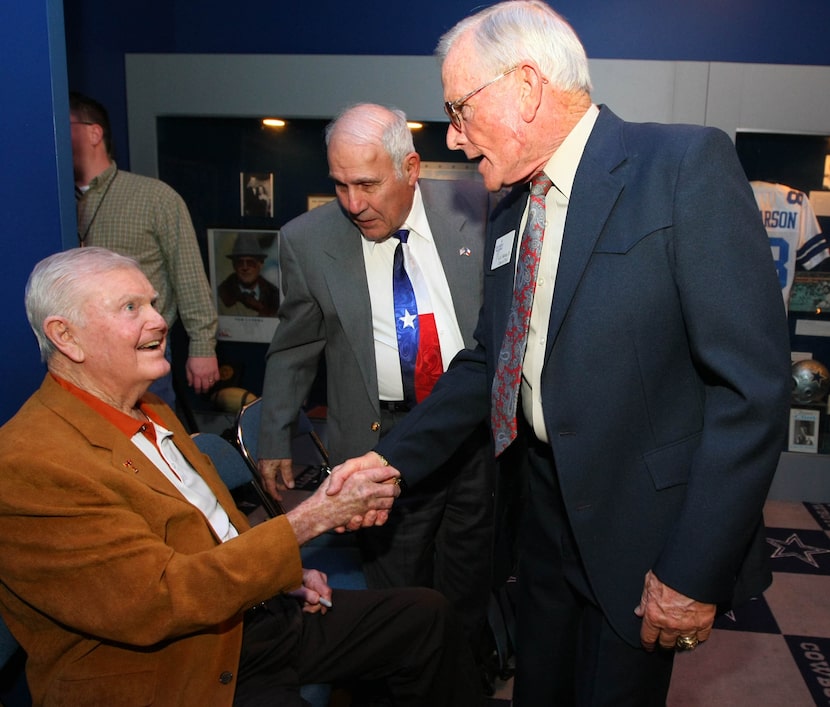 Former Texas football coach Darrell Royal, left, shakes hands with G.A. Moore Jr, right, ...