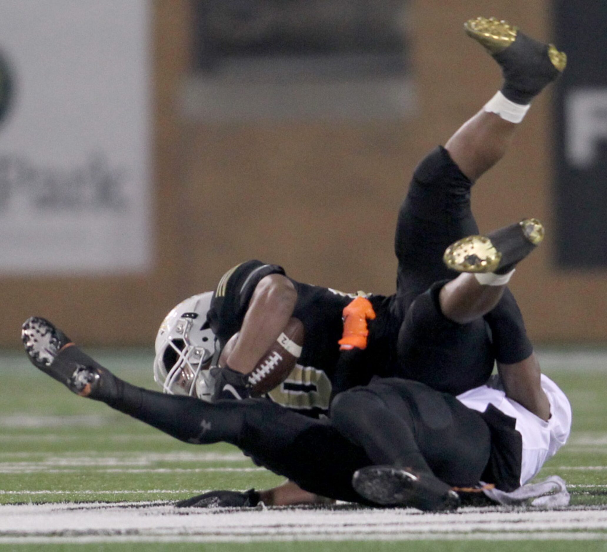 Wichita Falls Rider running back Latrevius Byrd (20) is upended by Aledo linebacker Ryan...