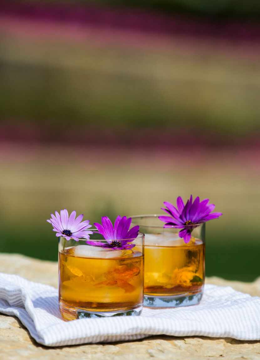 Rose Old Fashioned drinks garnished with African daisies, which are edible.