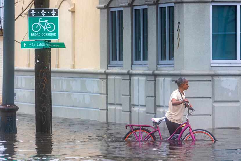 A cyclist pedals along a flooded street during a major thunderstorm, Wednesday, April 10,...