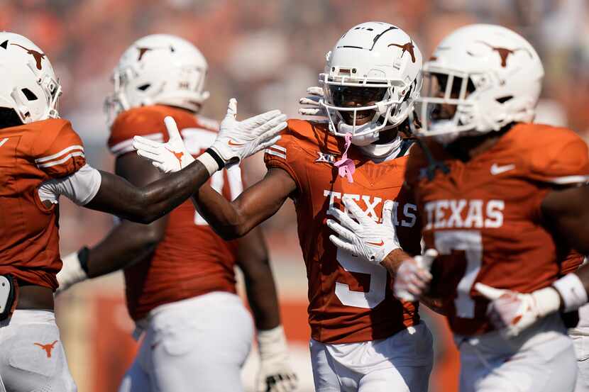 Texas wide receiver Adonai Mitchell (5) celebrates with teammates after catching a pass for...