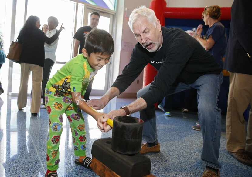 Aaron Noriega, 6, tested his strength on the Thunder God with the aid of Ray Vincelette on...