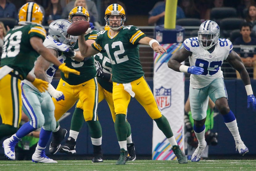 Green Bay Packers quarterback Aaron Rodgers (12) scrambles out of the pocket as he looks for...