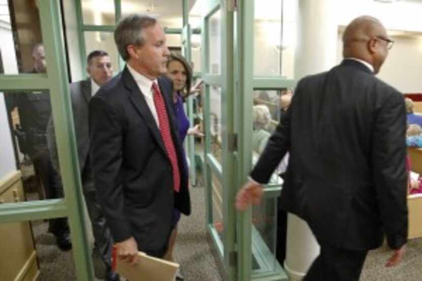 Texas Attorney General Ken Paxton (left) arrives in district court in Fort Worth on Aug. 27...