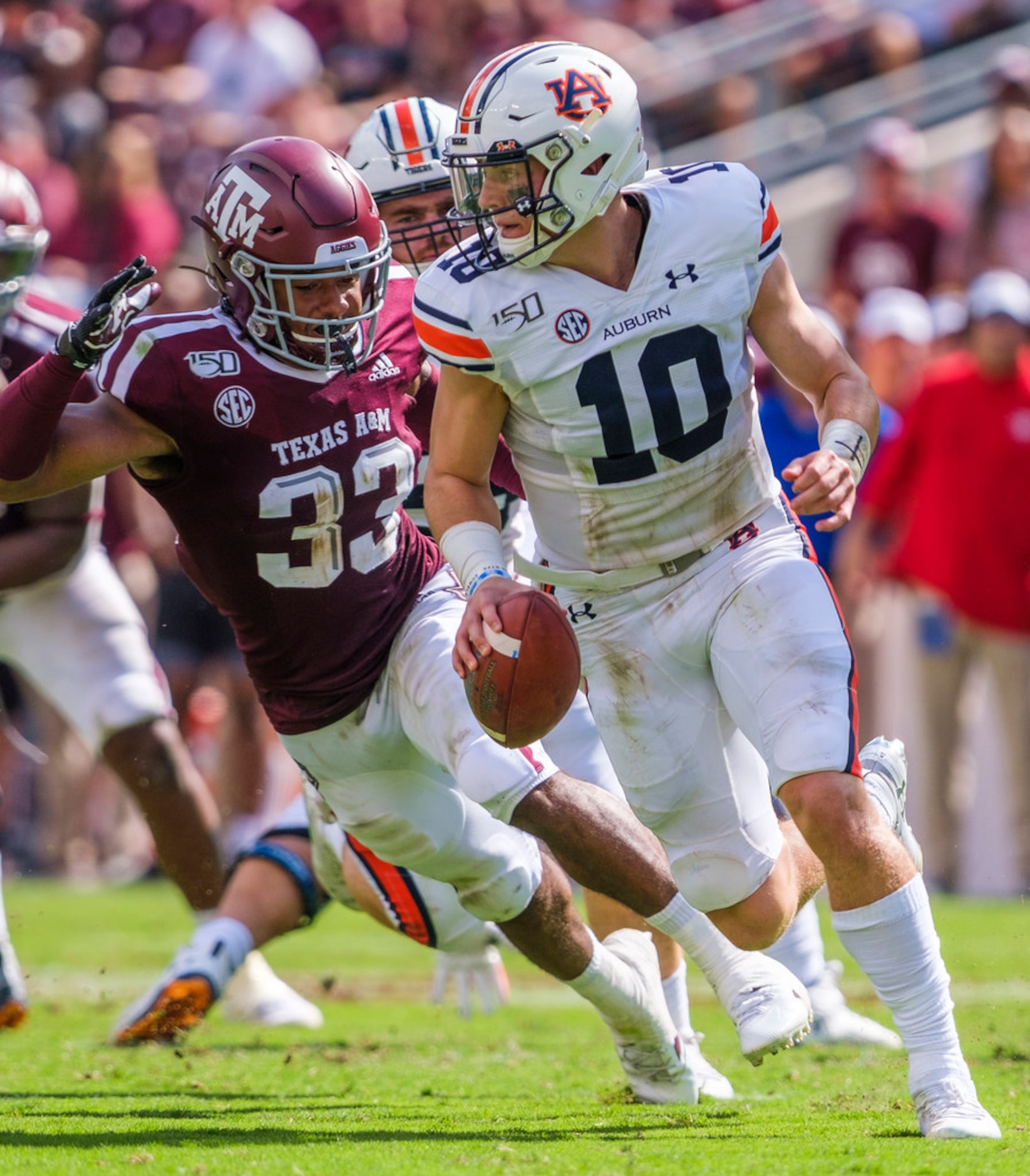 Auburn quarterback Bo Nix (10) scrambles away from Texas A&M linebacker Aaron Hansford (33)...