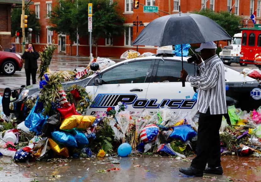 Thomas Freeney of Dallas took photos of the memorial at Dallas police headquarters in the...