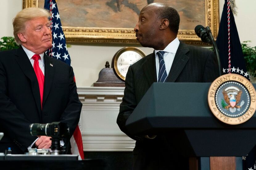 US President Donald Trump shakes hands with Ken Frazier (R), CEO of Merck, during the...
