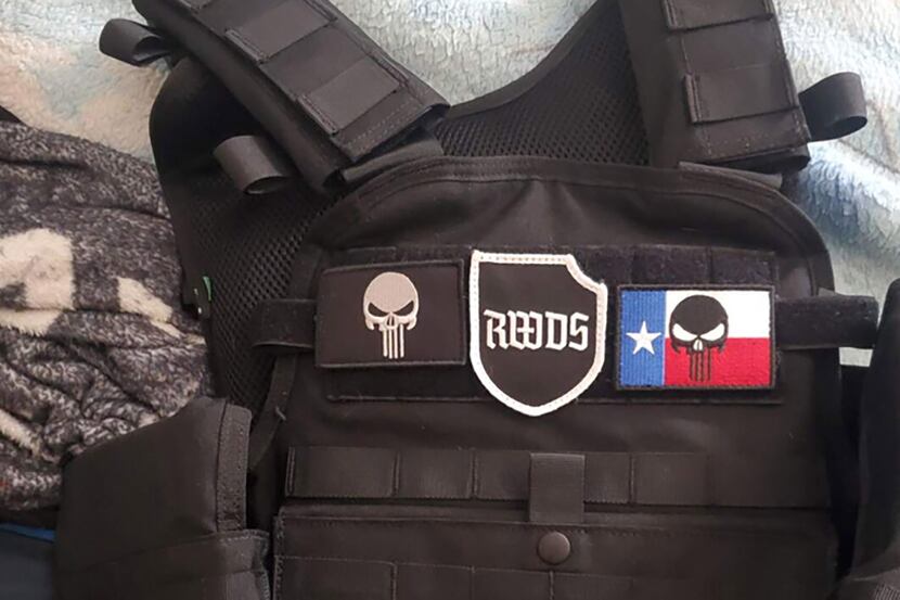 Image of a tactical vest with patches of the "Punisher" skull and "right-wing death squad,"...