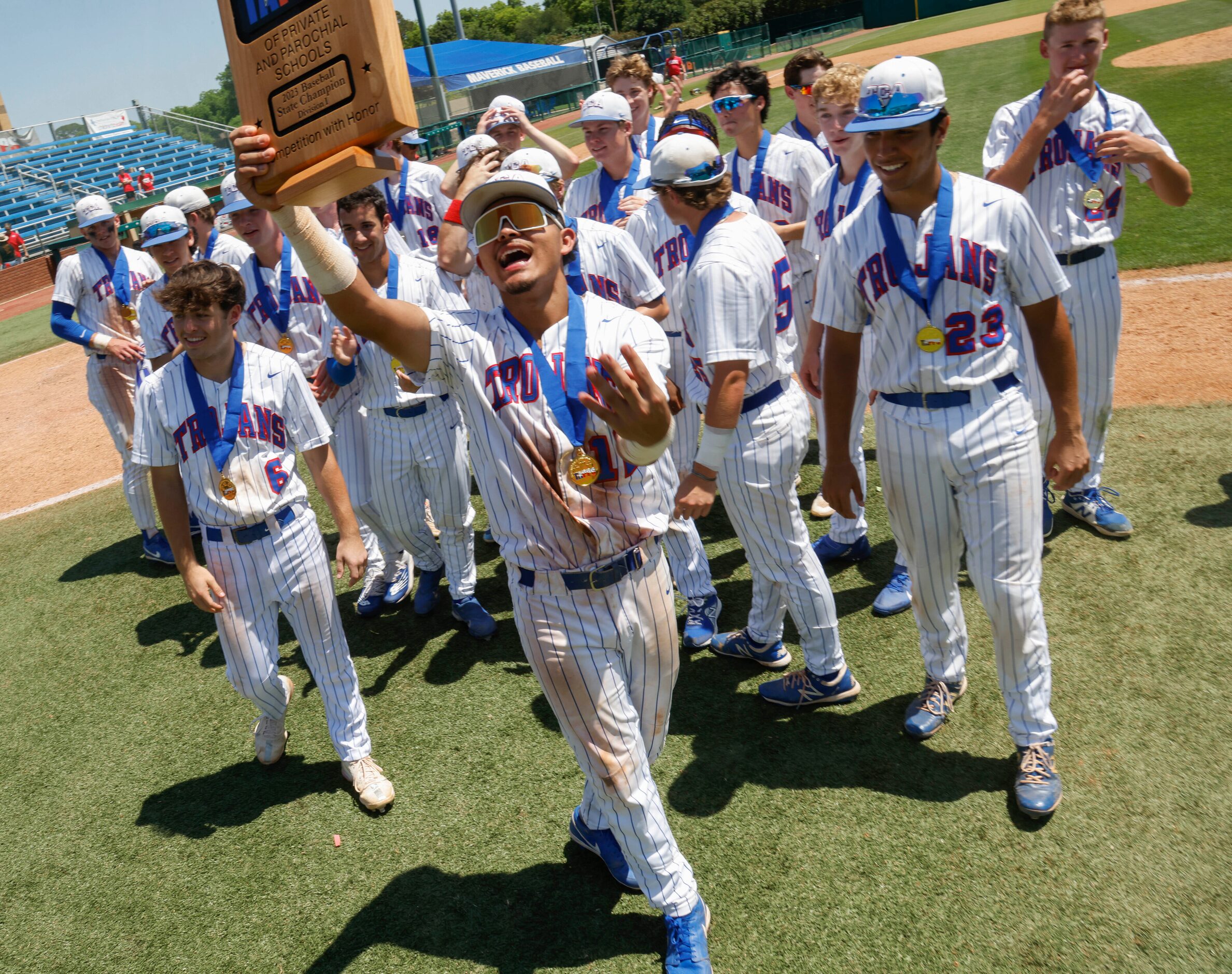 Trinity Christian’s Steven Ramos (12) holds the championship plaque after defeating Houston...