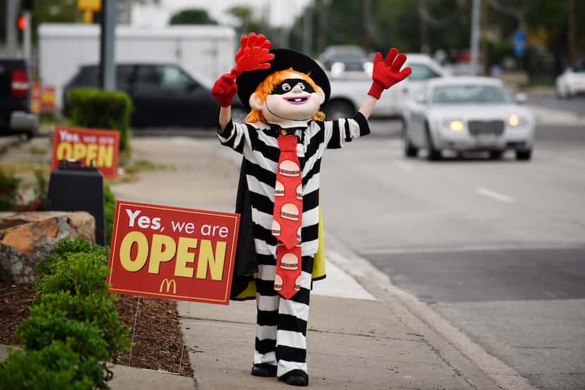 A McDonald's employee is dressed as the "Hamburglar," advertising the opening of the...