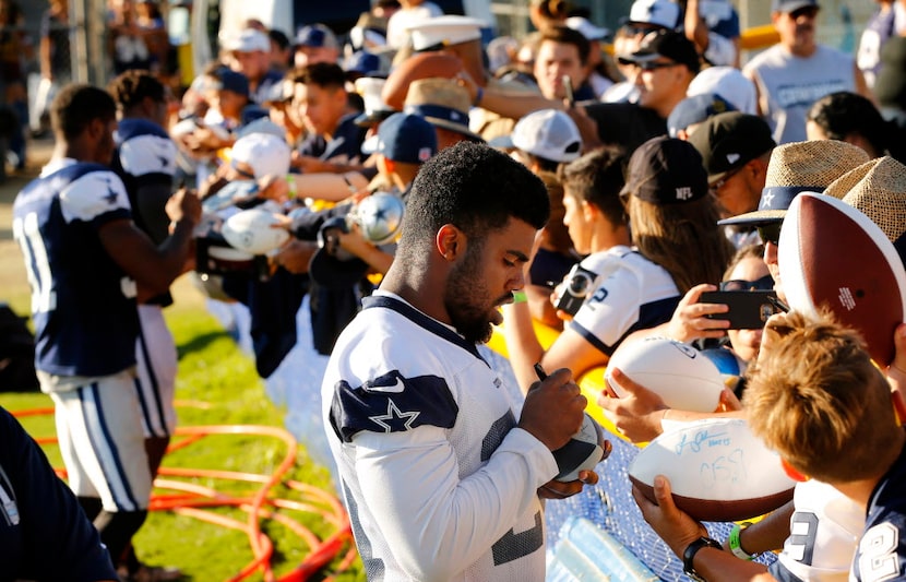 Dallas Cowboys running back Ezekiel Elliott (21) signs autographs for fans following...