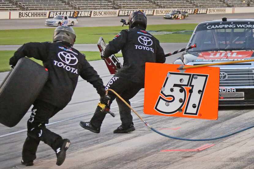 The pit crew of Spencer Davis hustles out during a pit stop during the NASCAR Camping World...