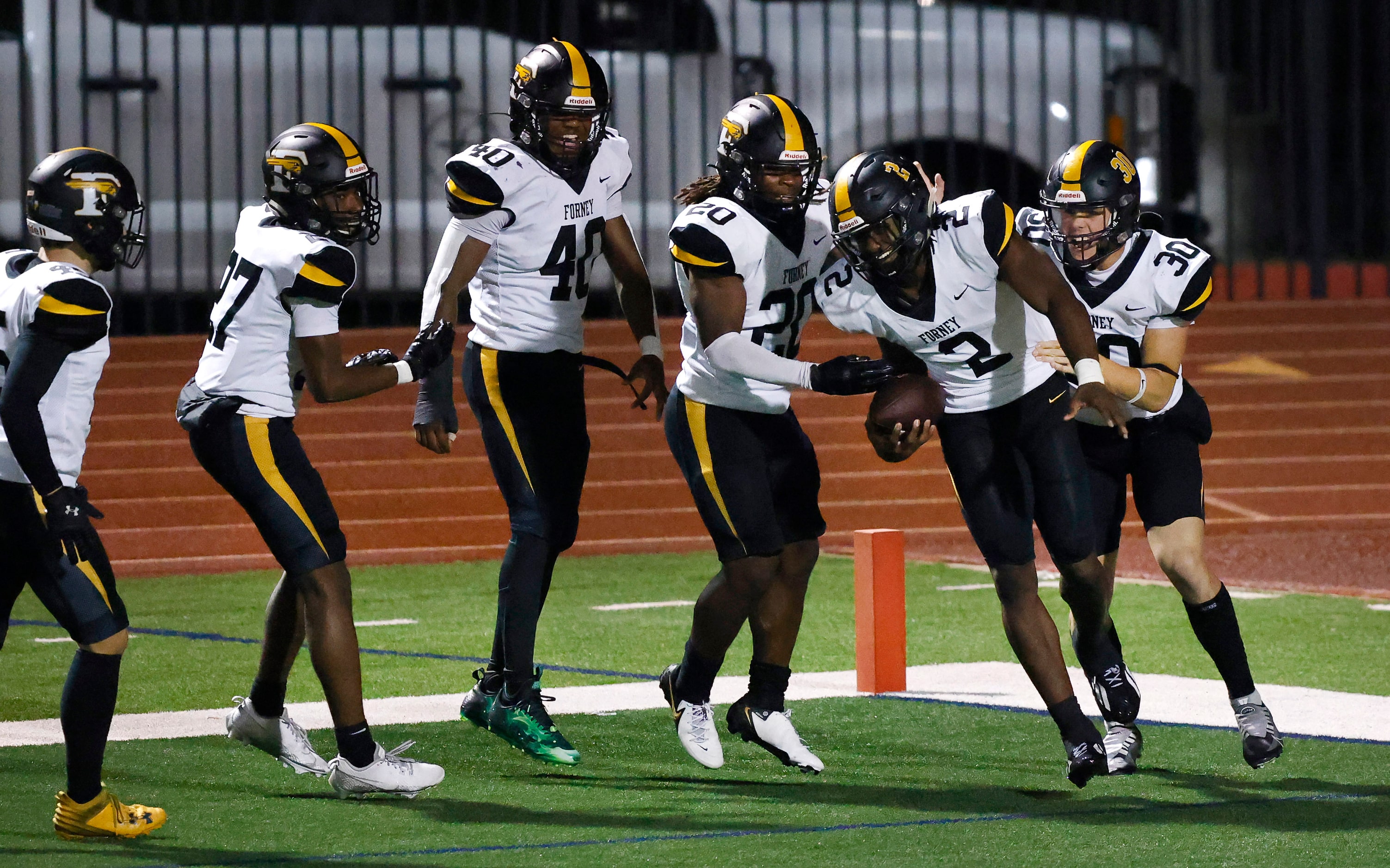 Forney linebacker Kelvion Riggins (2) is congratulated by teammates after he recovered his...