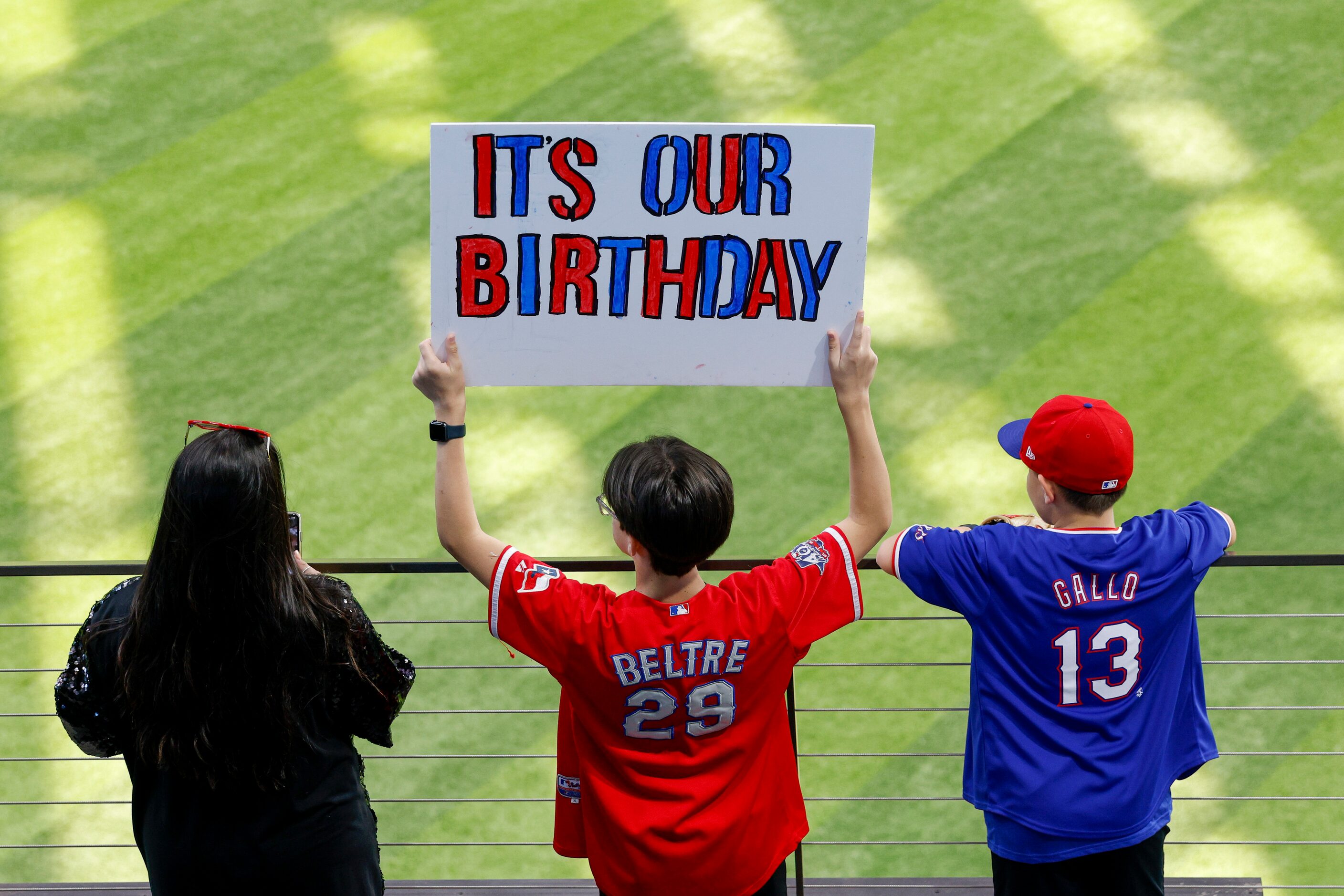 Logan Beck, 13 (center), raises a sign alongside his mother Jessica Beck (left), and brother...