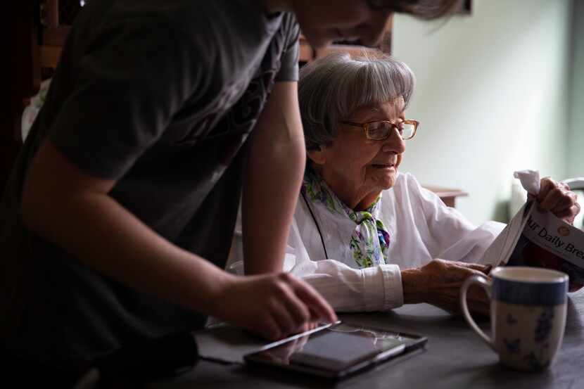 Beachum Wilder, 13, helps his great-grandmother Alice Palmeri pull up a Bible reading on her...