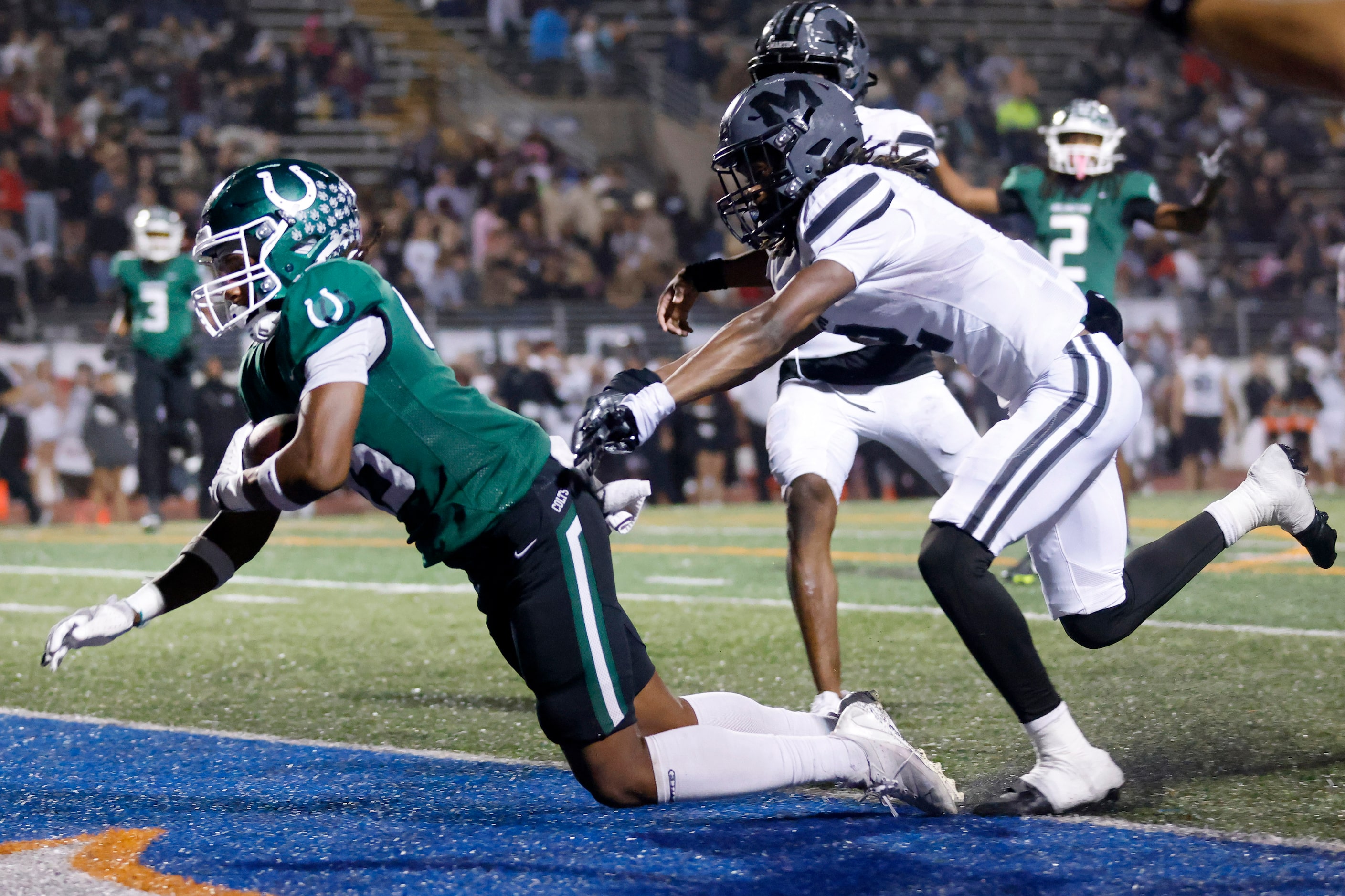 Arlington High wide receiver Isaiah Robertson (45) crosses the goal line as he’s shoved by...