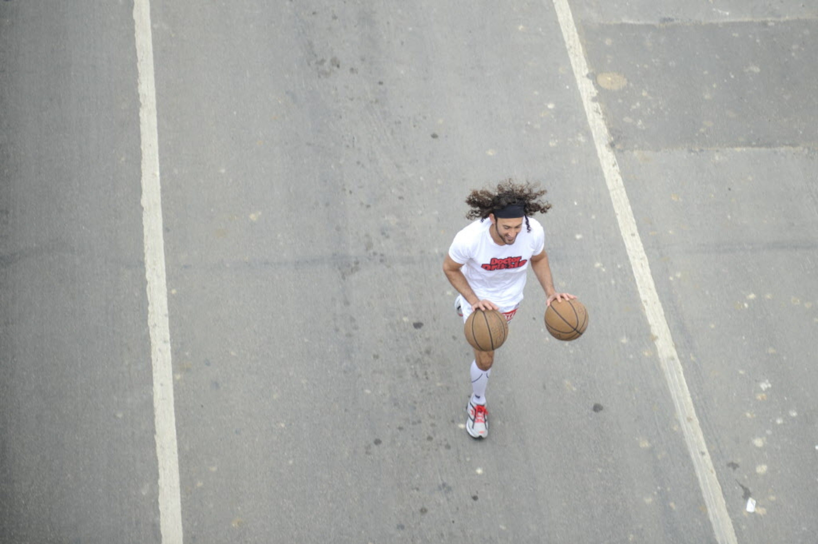 A runner dribbles two basketballs as he starts the Dallas Rock N' Roll half-marathon on...