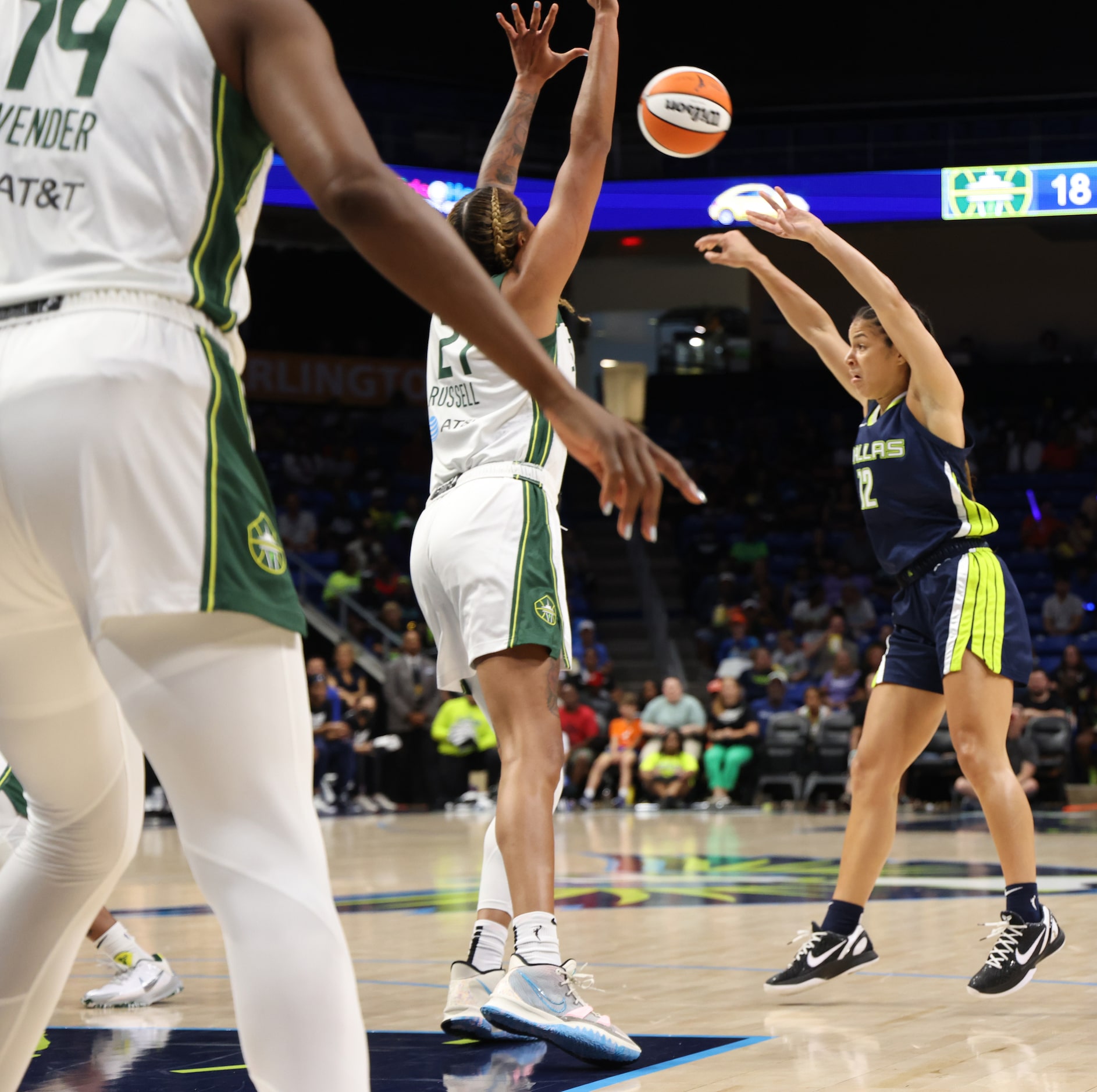 Dallas Wings guard Veronica Burton (12) skies a pass to a teammate over the defense of...