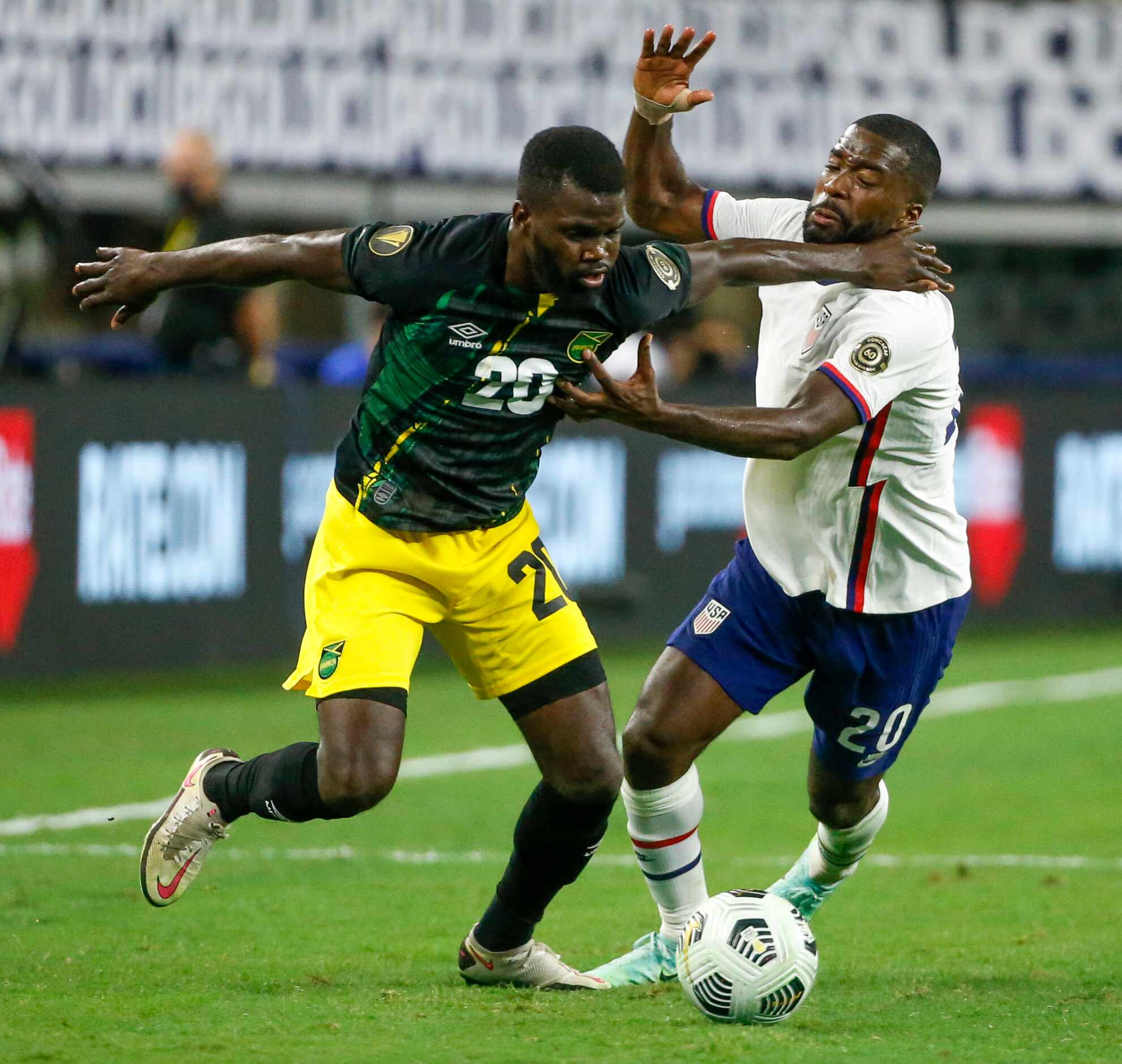 Jamaica defender Kemar Lawrence (left) and USA defender Shaq Moore battle for the ball...
