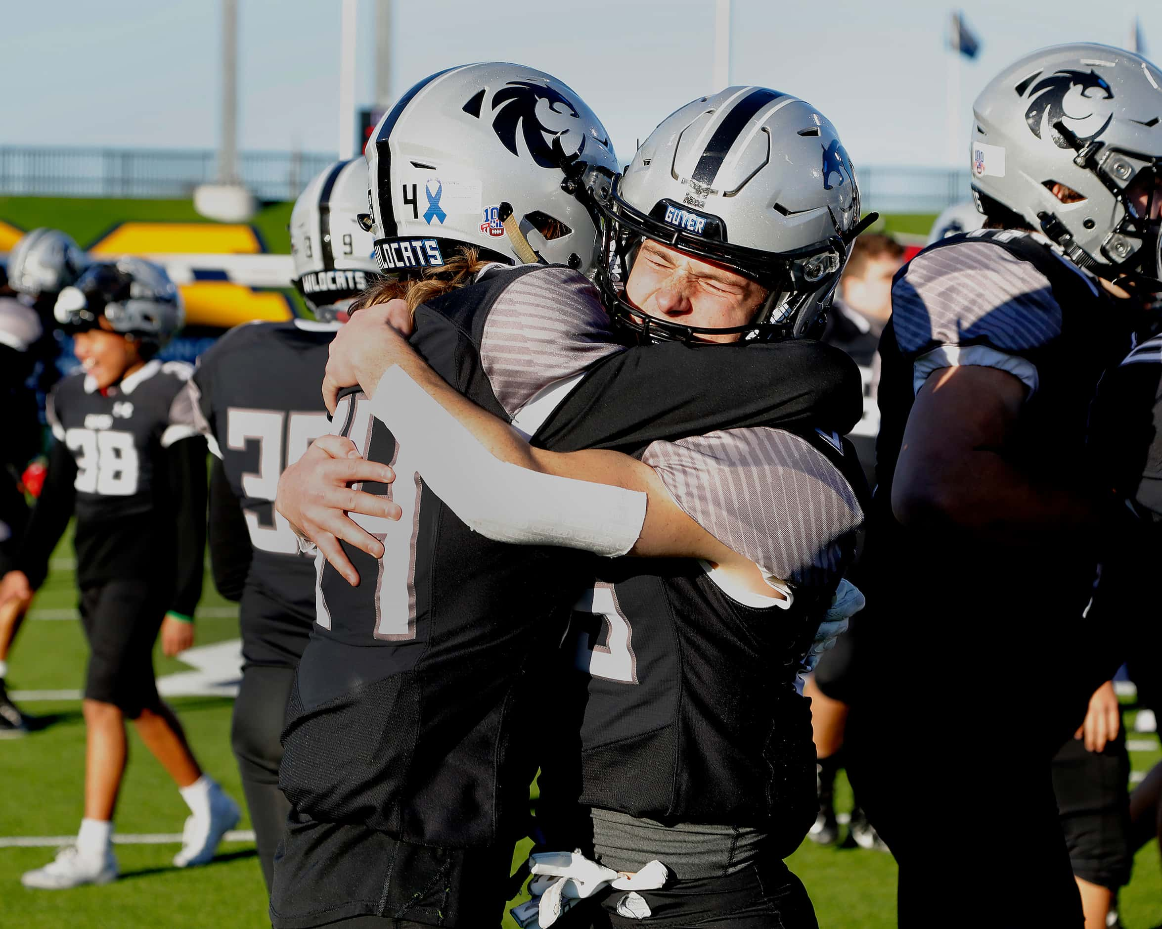 Denton Guyer High School wide receiver Bryson Riggs (34) embraces Denton Guyer High School...