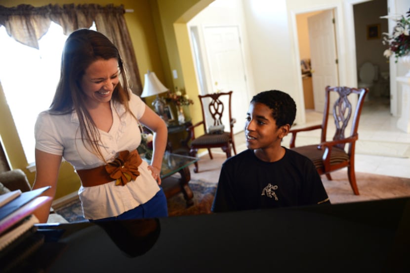 Roman Scott, 11, gets instruction from his piano teacher, Megan Maxwell, at his home in...