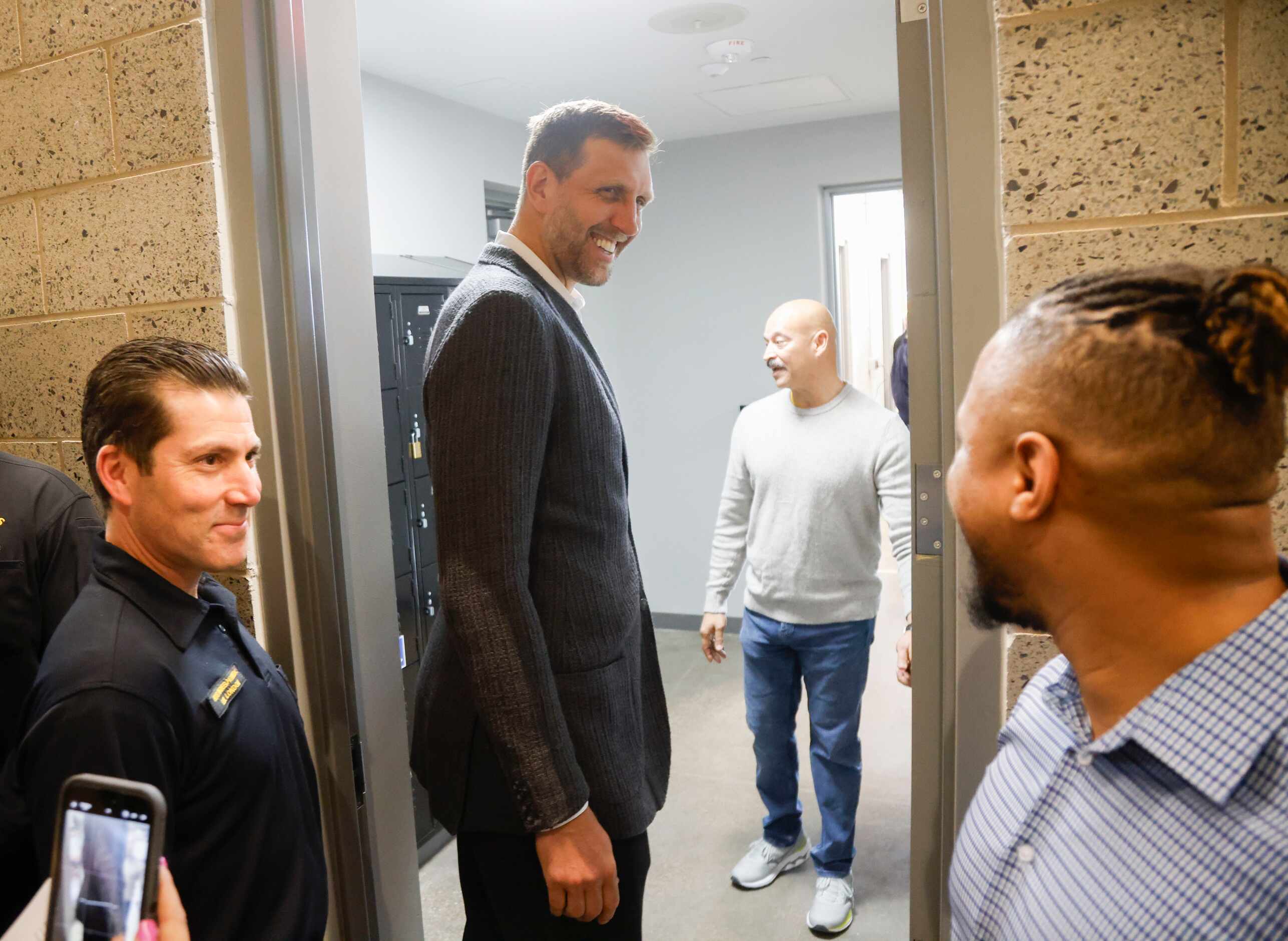Dallas Mavericks Hall of Famer Dirk Nowitzki (center) smiles while getting a tour before the...