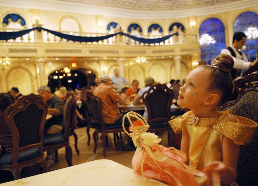 Rosie Pramik at the Be Our Guest Restaurant, where chandeliers hang from a ceiling painted...