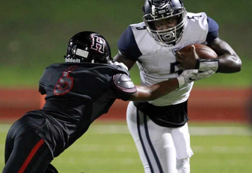 Wylie East QB Eno Benjamin (5) is stopped as he tries to get around Rockwall-Heath defender...