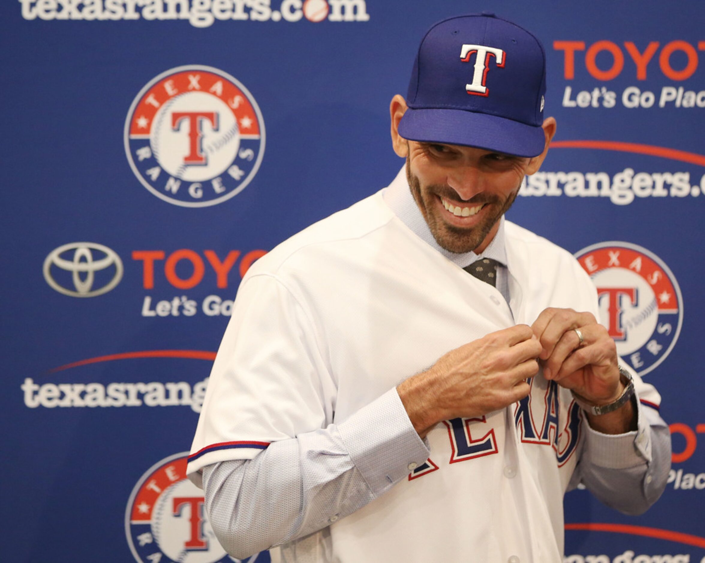 Texas Rangers' new manager Chris Woodward puts on a Texas Rangers jersey during a press...