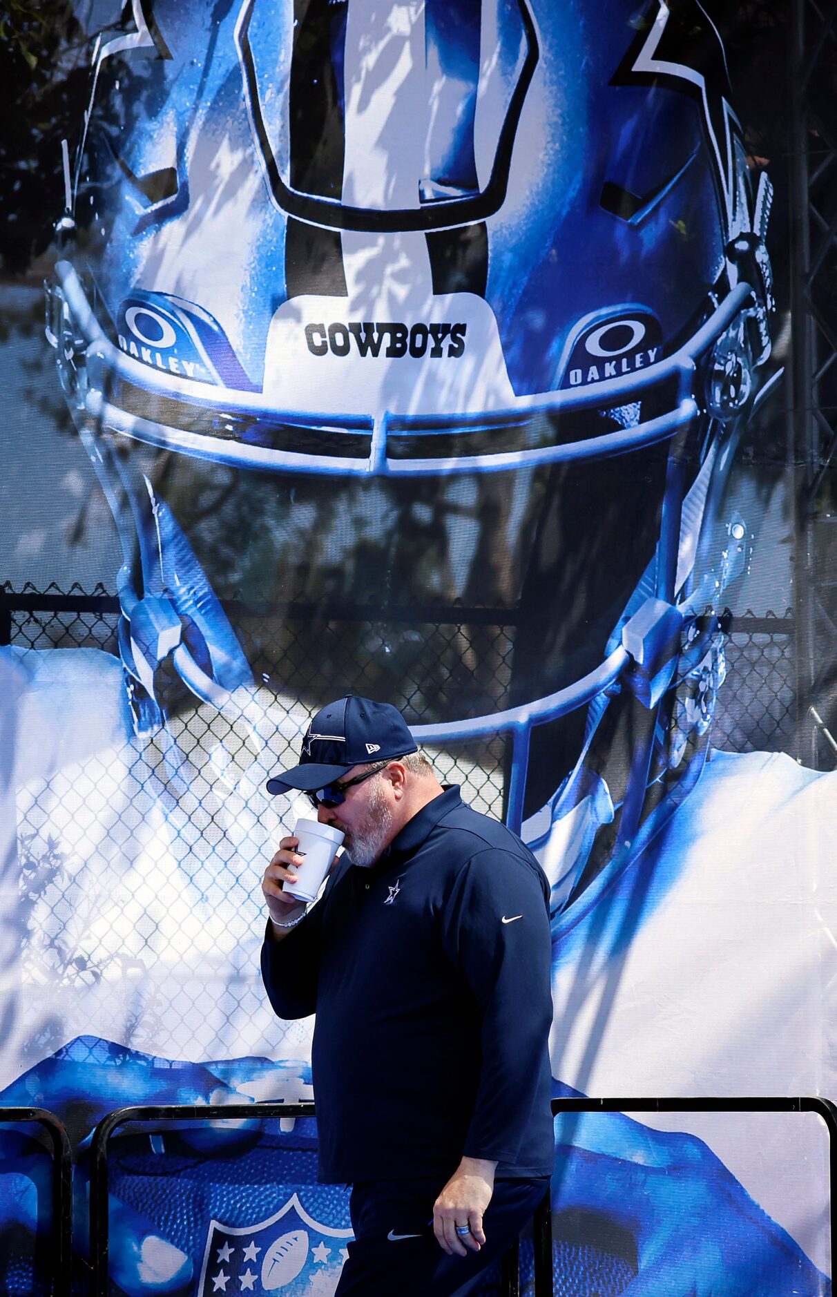 Dallas Cowboys head coach Mike McCarthy  takes one last sip of coffee as he approaches the...