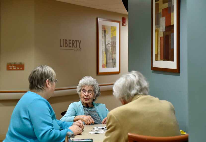 Phylas Lose, center, plays cards with her daughter Jan Morehead (left) and a friend at...