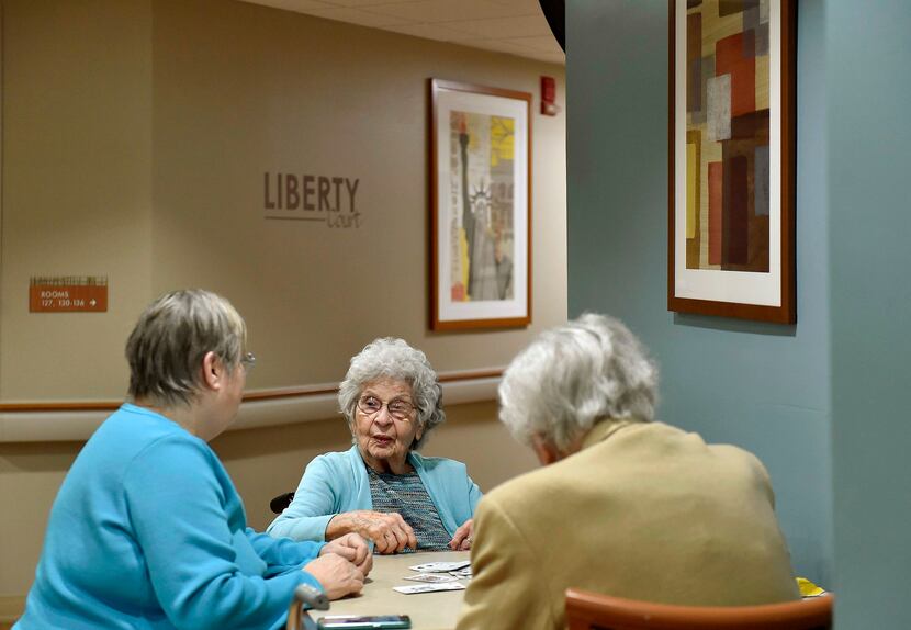 Phylas Lose, center, plays cards with her daughter Jan Morehead (left) and a friend at...