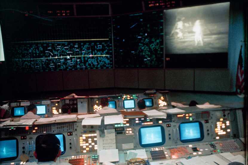 In this July 20, 1969 photo made available by NASA, flight controllers work in the Mission...