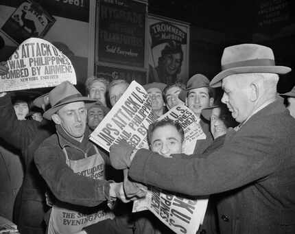 In this Dec. 7, 1941, file photo, people buy newspapers reporting the Japanese attack on...