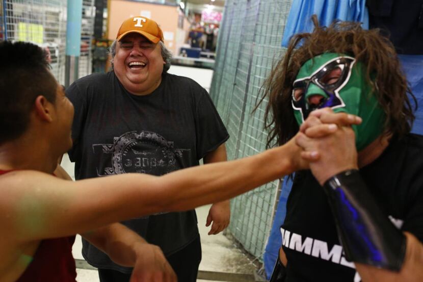 
El Siniestro (right) pretends to bite Eli Herrera’s fingers as promoter Sergio Reyes laughs...