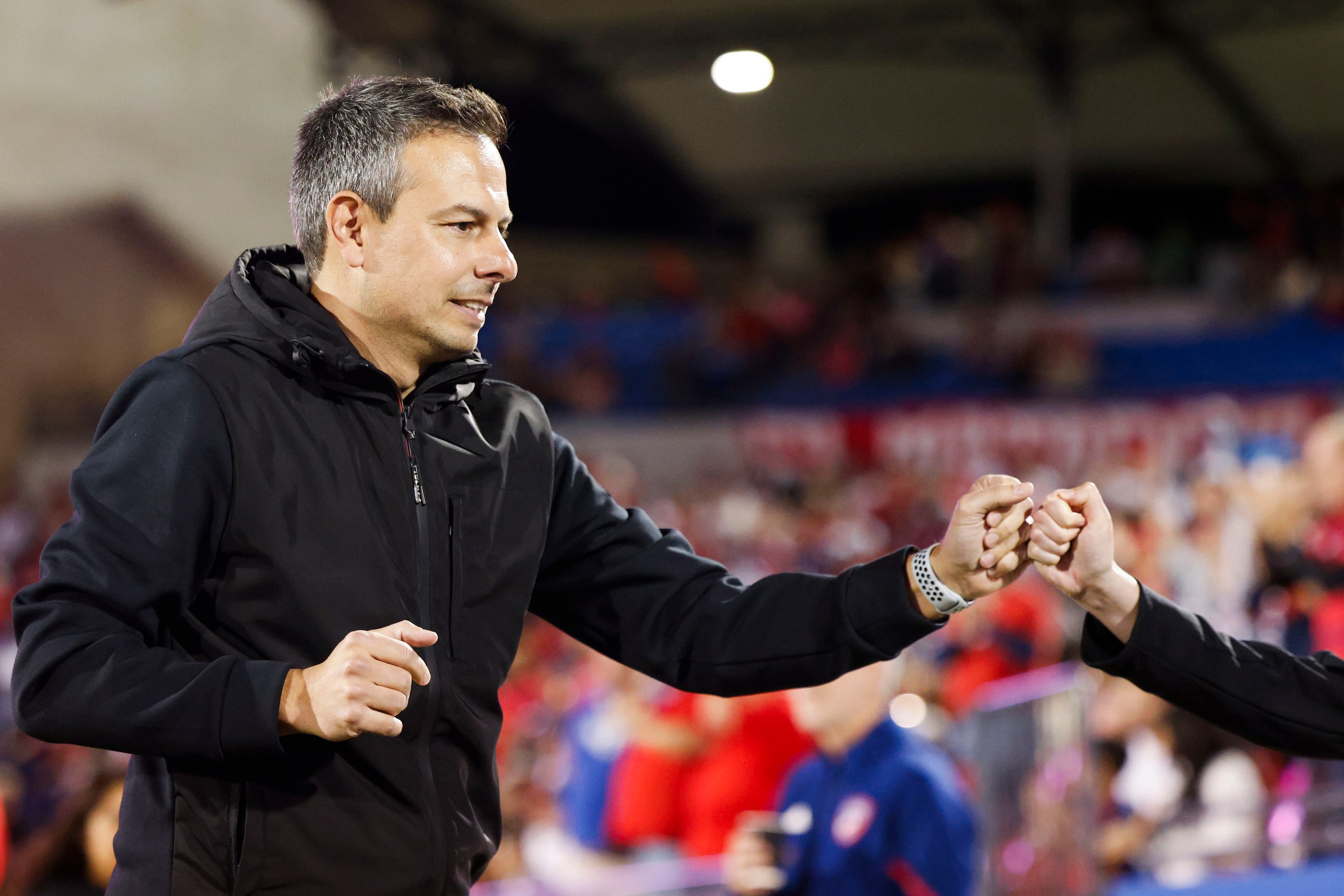 FC Dallas head coach Nico Estévez fist bumps as he enters the field ahead of an MLS soccer...