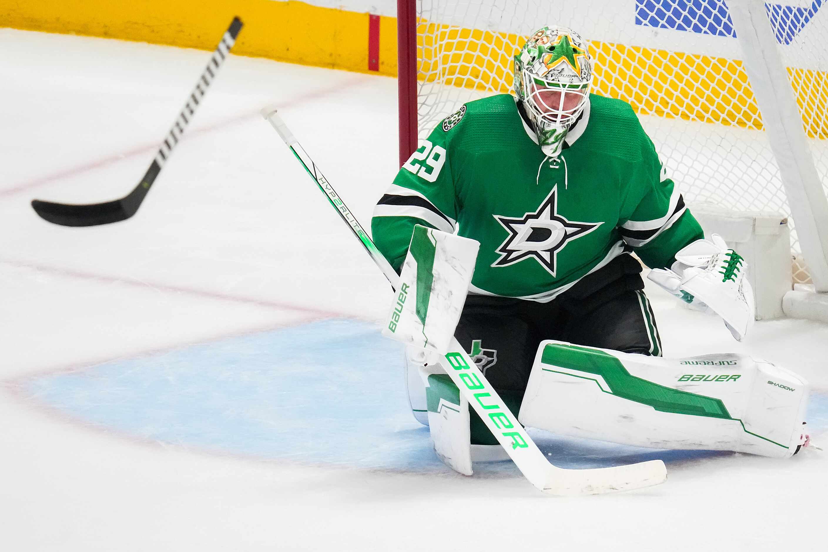 A loose stick flies across the crease in front of Dallas Stars goaltender Jake Oettinger...