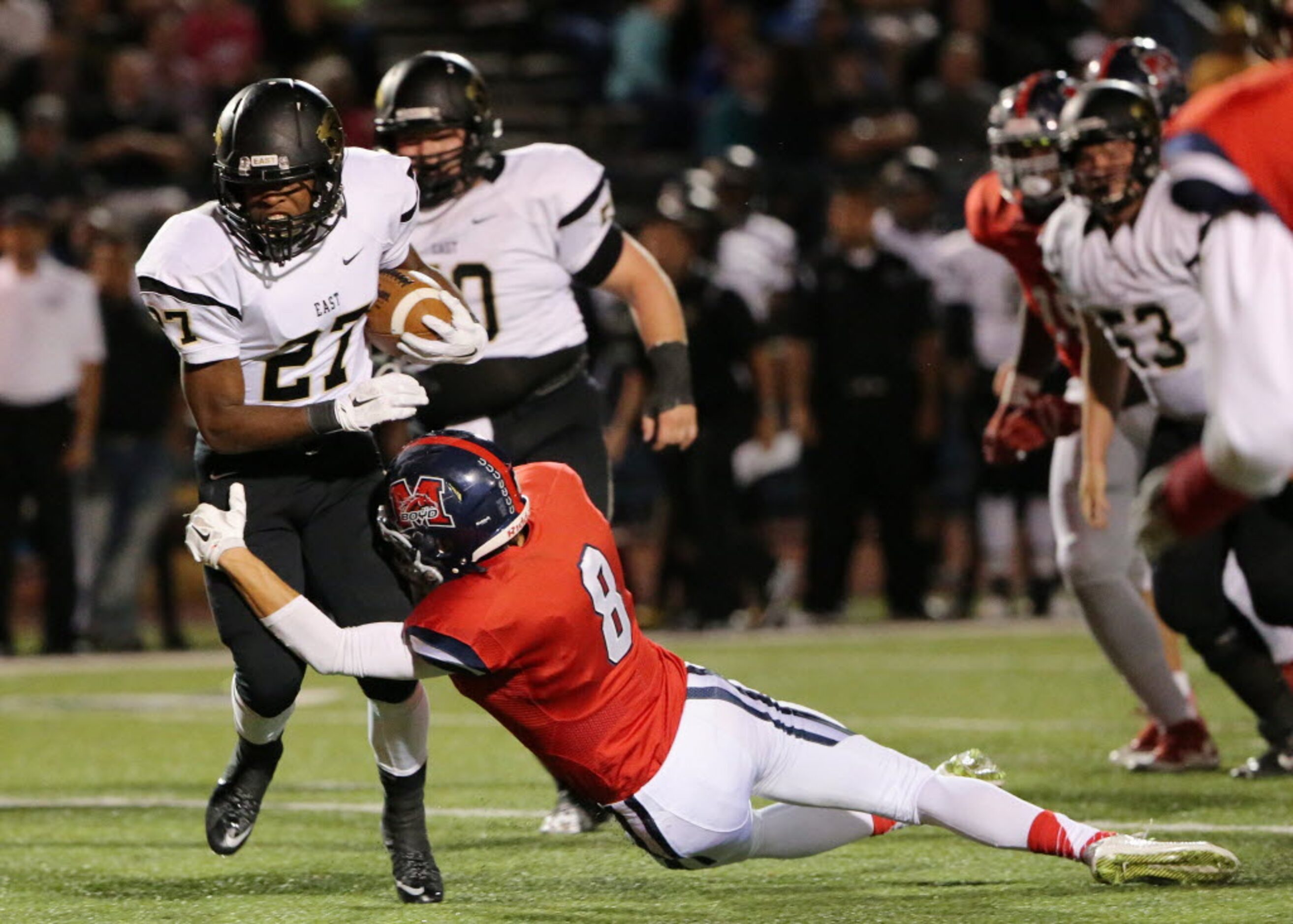 Plano East running back Jonathan Meadors (27) attempts to avoid a tackle by McKinney Boyd...