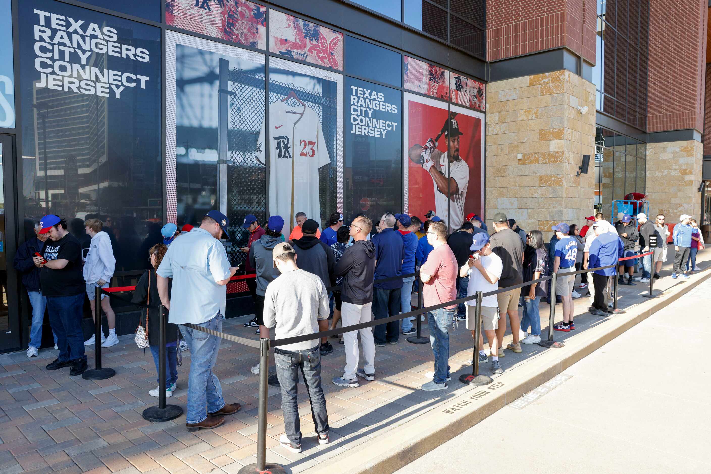 Texas Rangers fans gather outside the Grand Slam Team Store to purchase new City Connect...