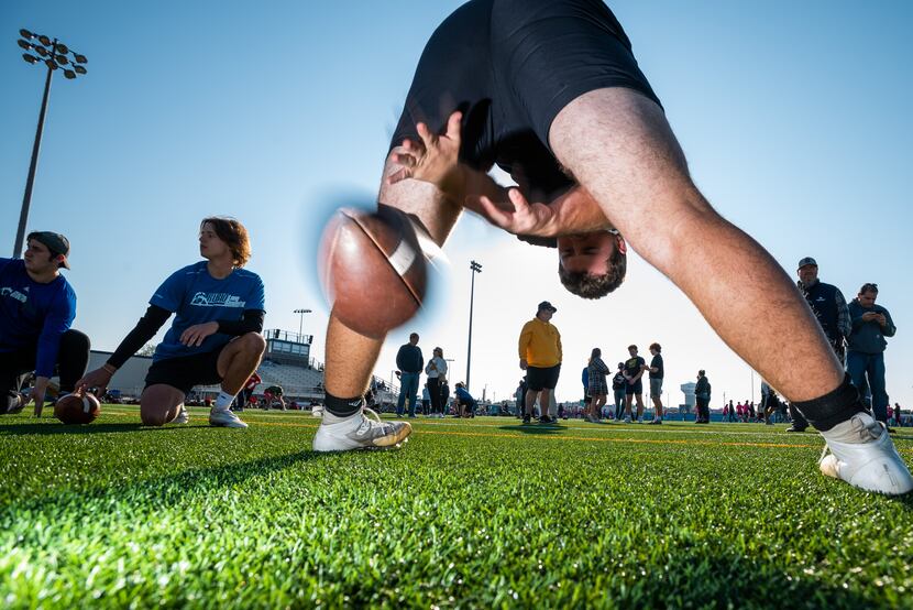 Bailey Sanders, 17, snaps a football between his legs as he works on technique during a...