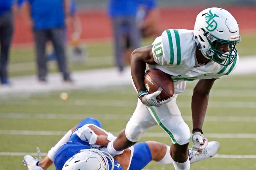 Lake Dallas High School wide receiver Keonde Henry (10) tries to escape the grasp of Frisco...