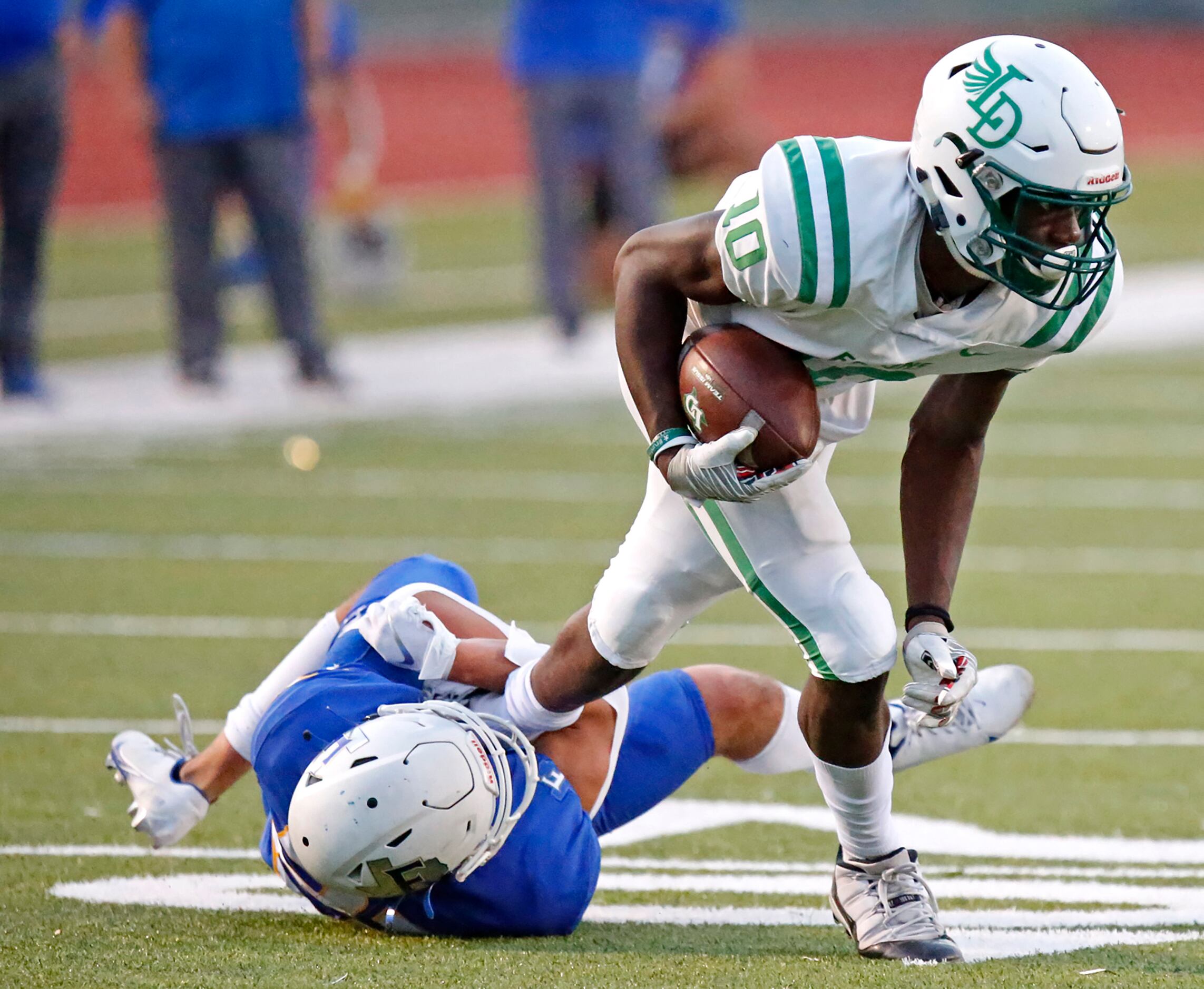Lake Dallas High School wide receiver Keonde Henry (10) tries to escape the grasp of Frisco...